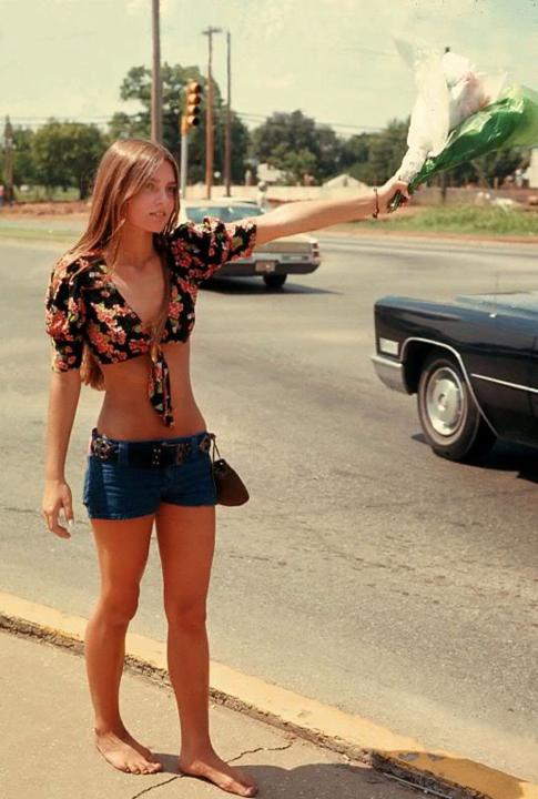 Woman selling roadside flowers in Oklahoma in 1973 Young woman selling flowers, barefoot, on the side of the road