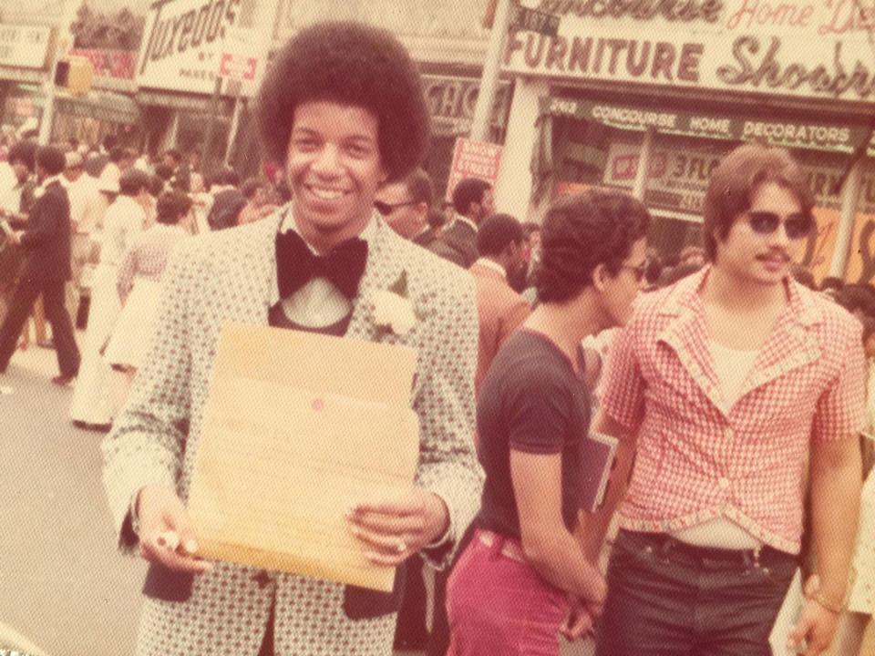"My dad after graduating from high school in the Bronx" A man in a suit smiling with his diploma