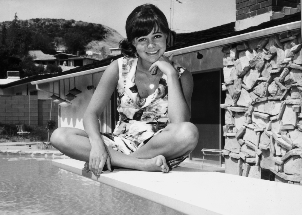 Sally Field poses by a swimming pool.