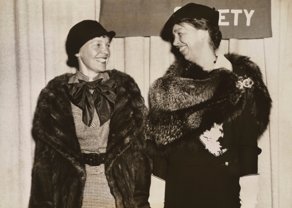 Amelia Earhart and Eleanor Roosevelt smile at event