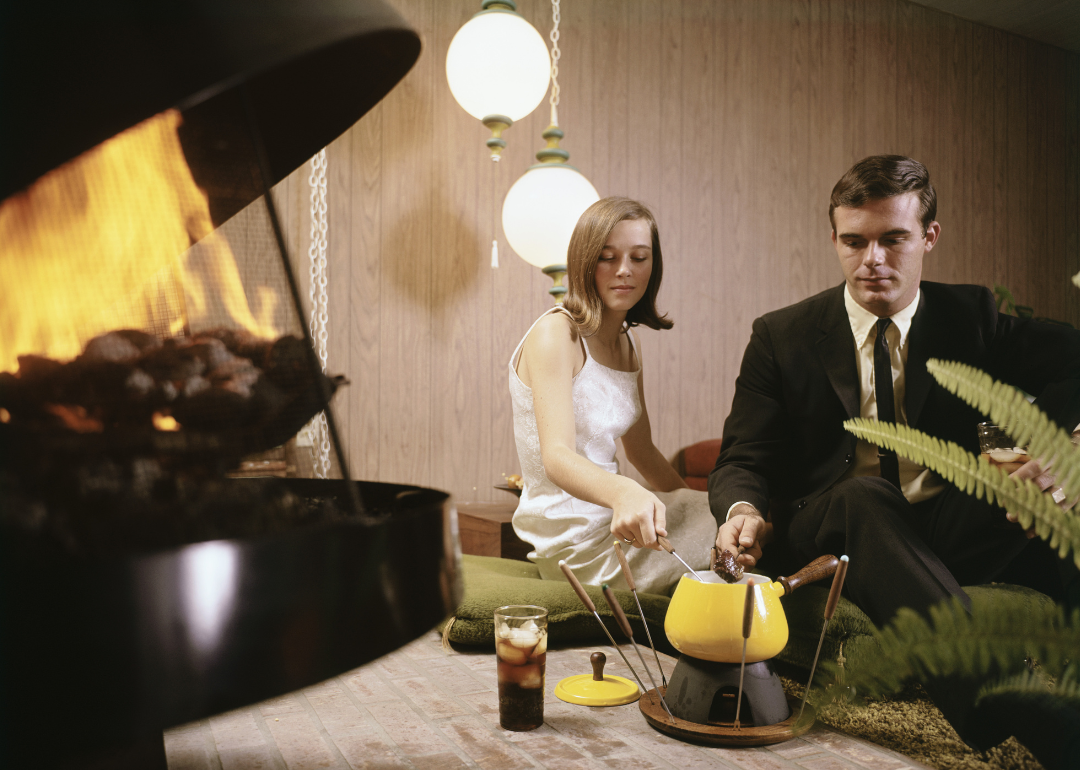 Young couple sitting by fireplace making fond du.