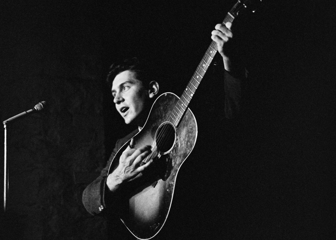Phil Ochs performing with guitar.