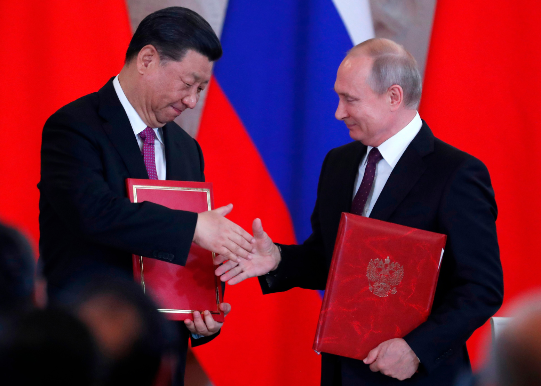 Vladimir Putin and Xi Jinping shake hands at signing ceremony following Moscow talks