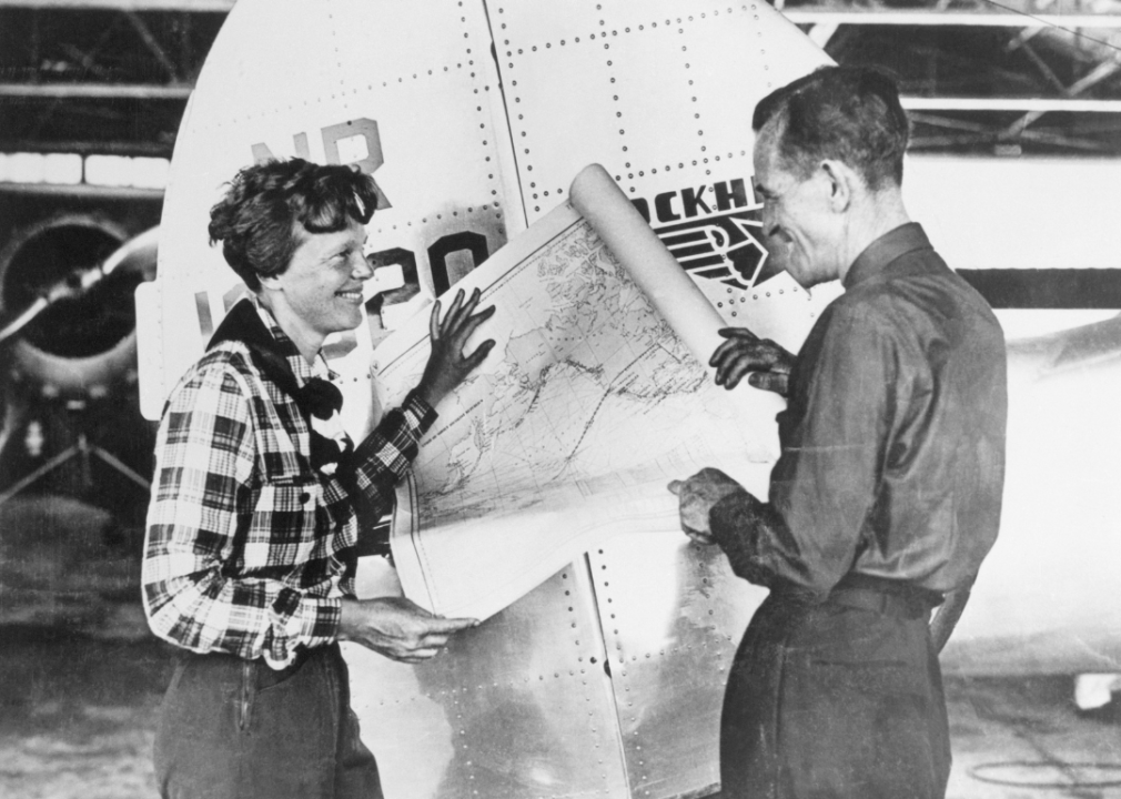 Amelia Earhart and Fred Noonan with a map showing flight route