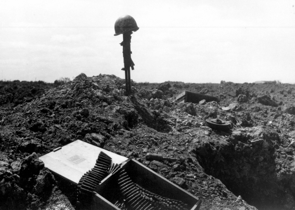 A rifle and helmet mark the site of a fallen soldier in Normandy.