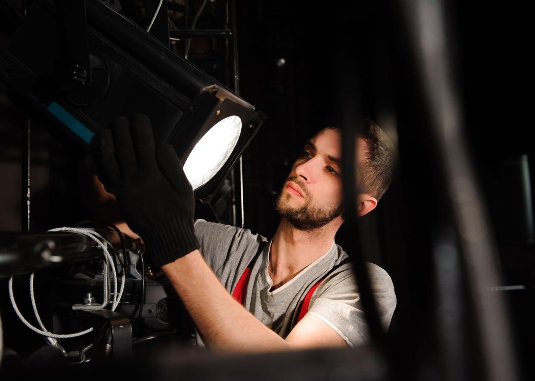 Man adjusting stage light