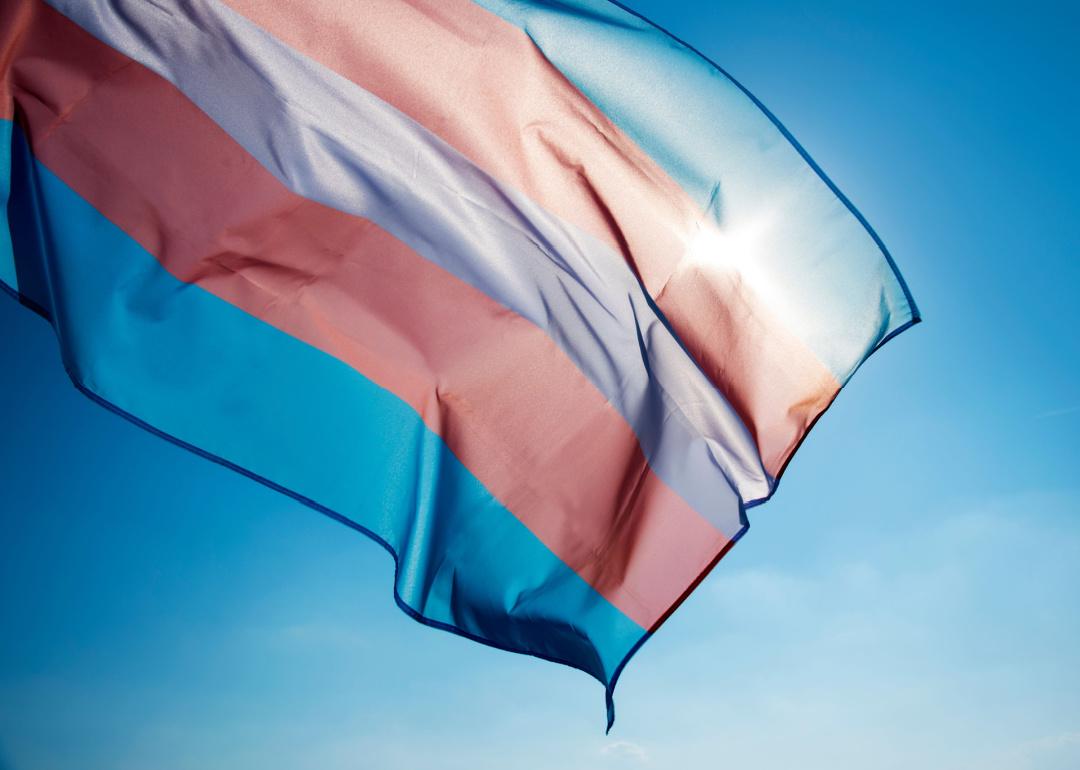 Transgender pride flag waving on blue sku