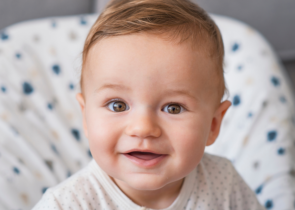 Baby with brown eyes and red hair smiling portrait.