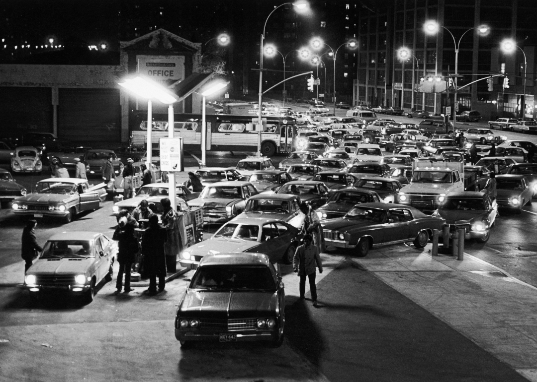 Large crowd of cars lined up for gas at night.