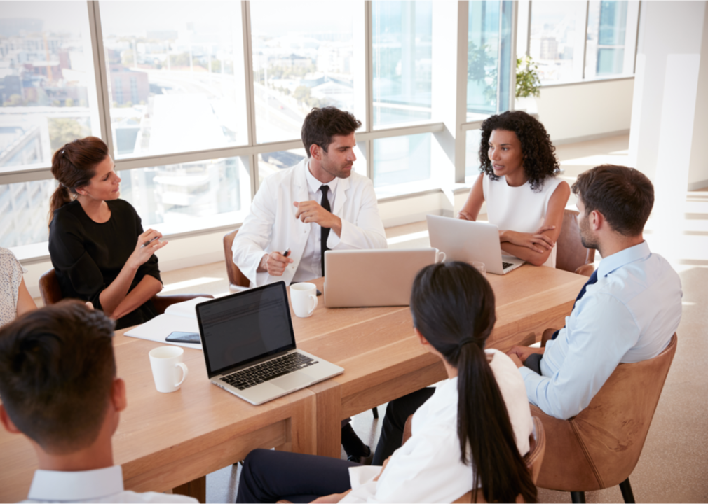 Group of medical professionals and administrators in meeting.