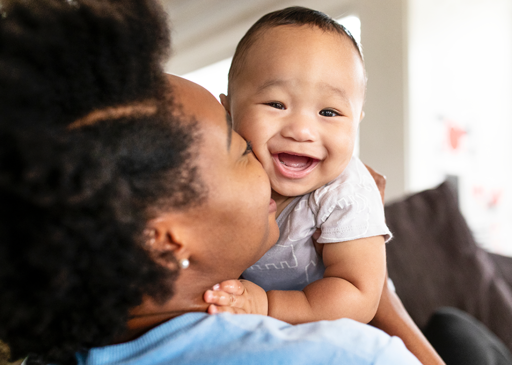 Happy mother kissing smiling baby.