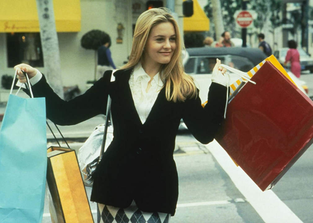 Alicia Silverstone crosses the street with shopping bags in a scene from ‘Clueless’.