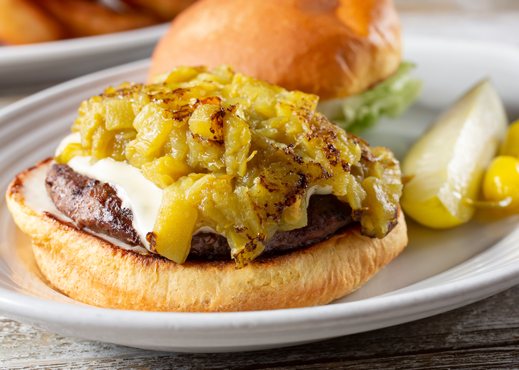 Open face green hatch chile cheeseburger on a plate.