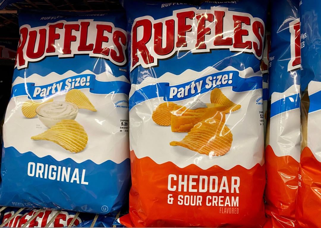Large bags of Ruffles chips on store shelf.