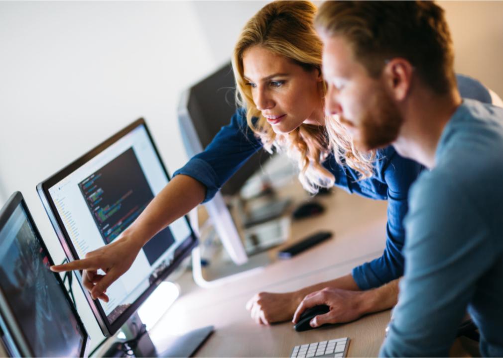 Two coworkers discuss computer systems.
