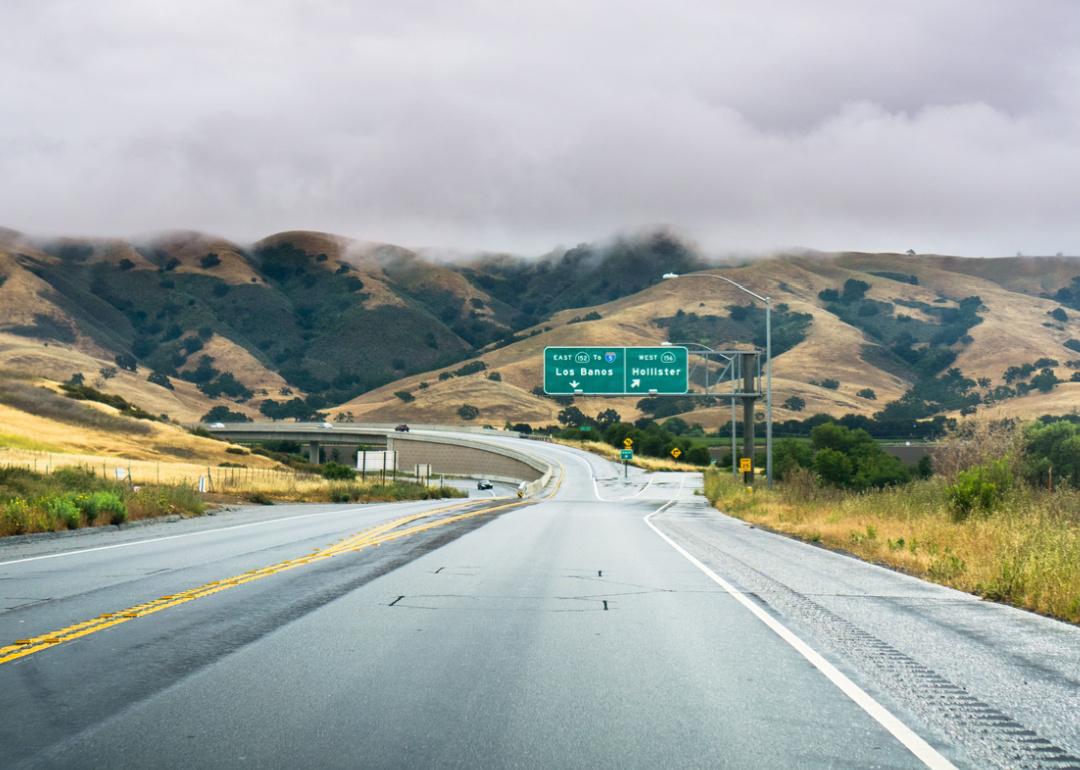 Highway on cloudy day with exit sign to Los Banos and Hollister.