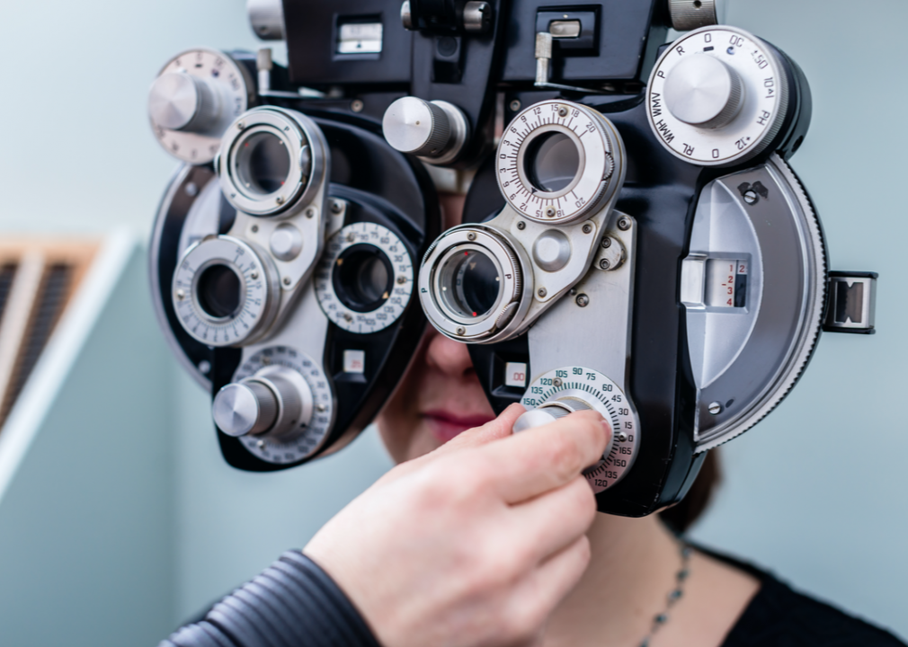 Optometrist adjusts optical equipment.