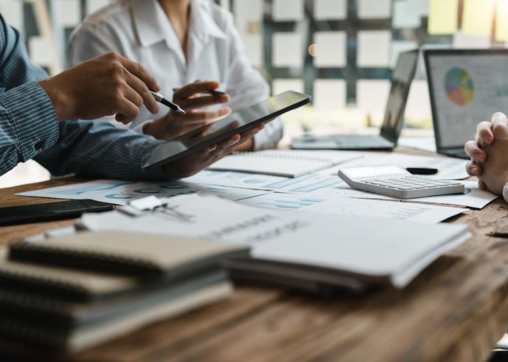 Financial advisor meets with clients to discuss reports.
