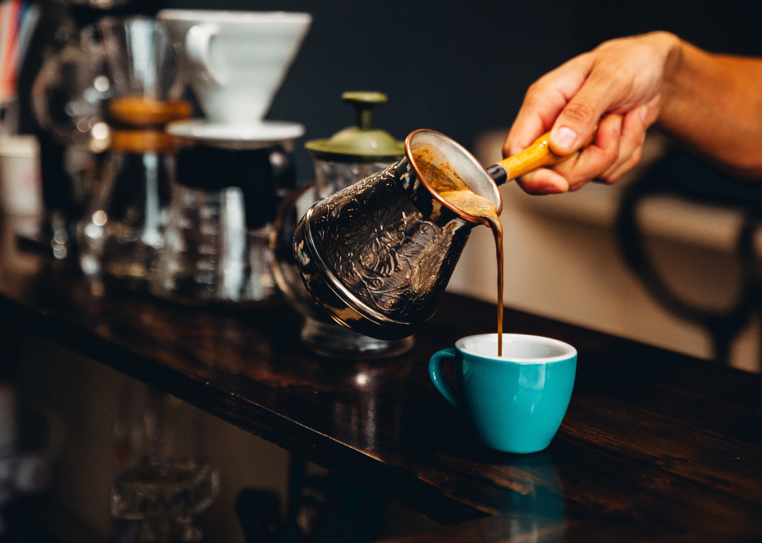 Barista pouring specialty coffee drink.