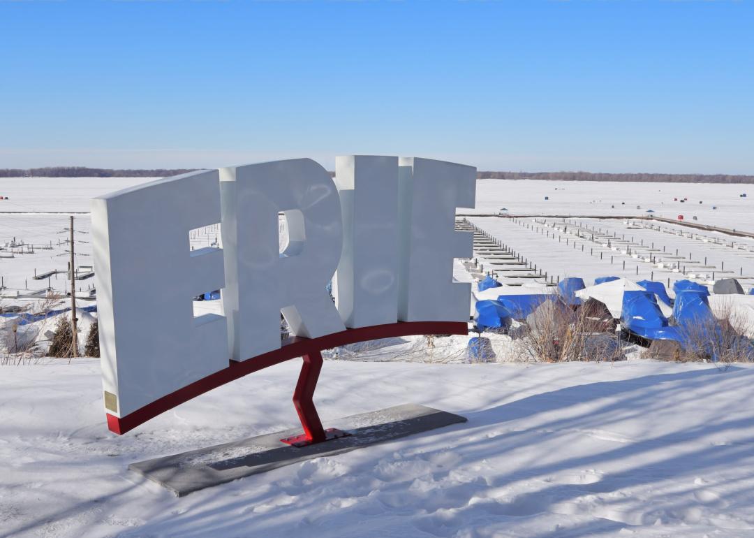 Snow covered Erie Sign with Presque Isle Bay in background.