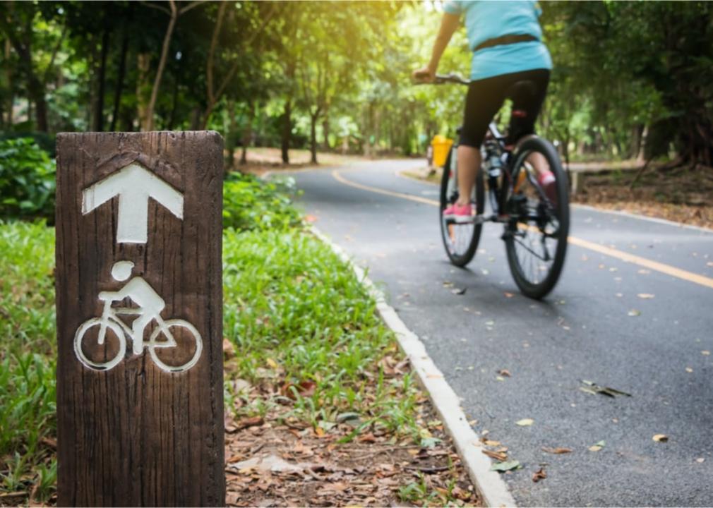 Person riding bicycle on park trail.