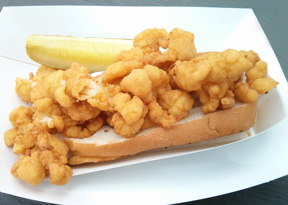 Deep-fried clam strips on a bun with a pickle.
