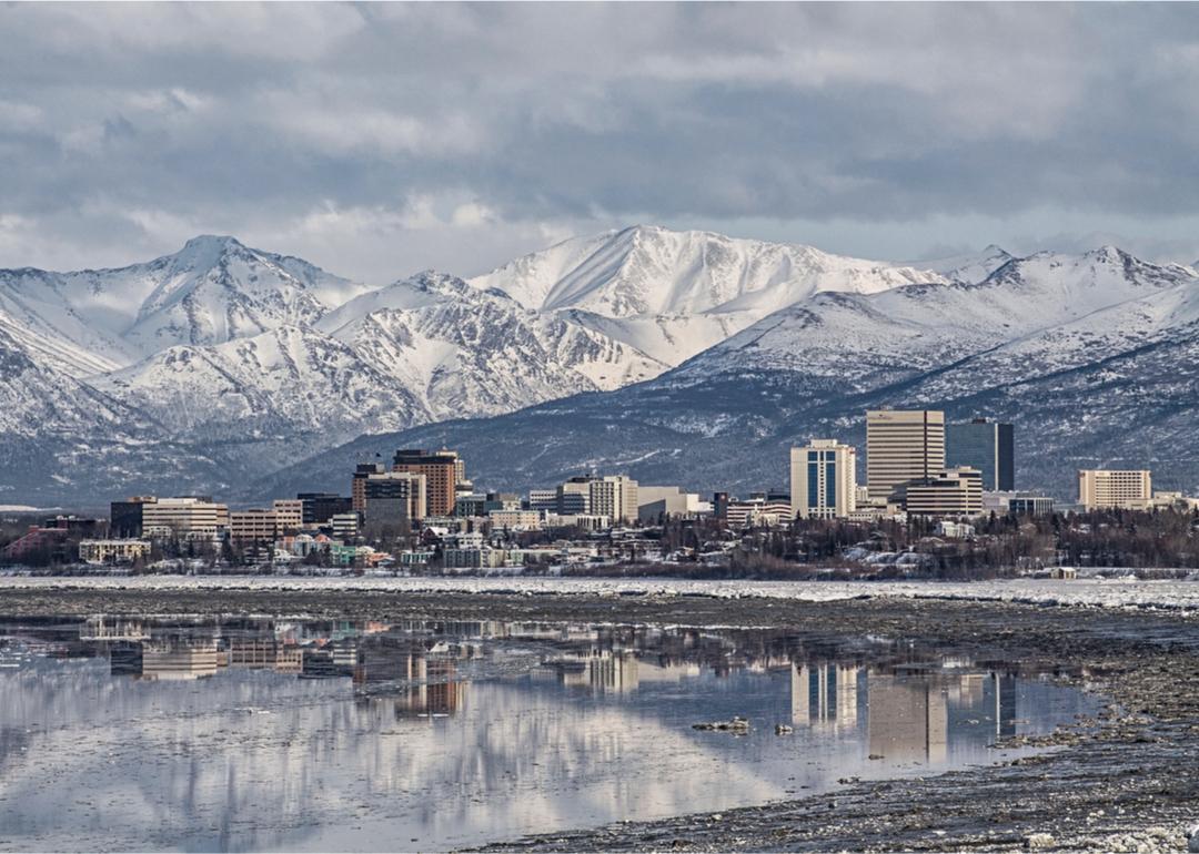 Snowy landscape with city of Anchorage and mountains.
