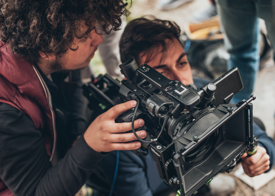 Cameraman and assistant shooting outdoor film scene.