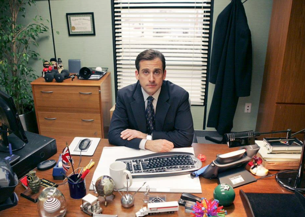 Steve Carell seated at desk in a publicity still for ‘The Office.’