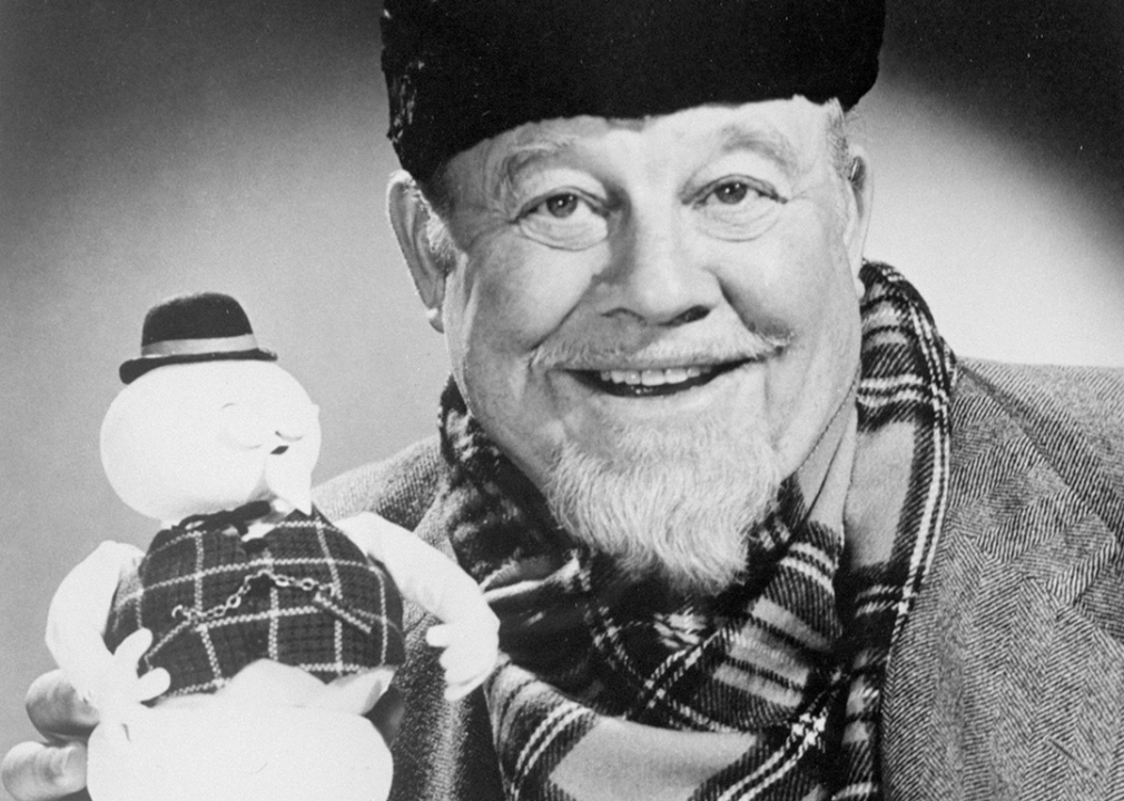 Burl Ives holds up the stop-motion snowman puppet of Sam from the Christmas special, Rudolph the Red-Nosed Reindeer.