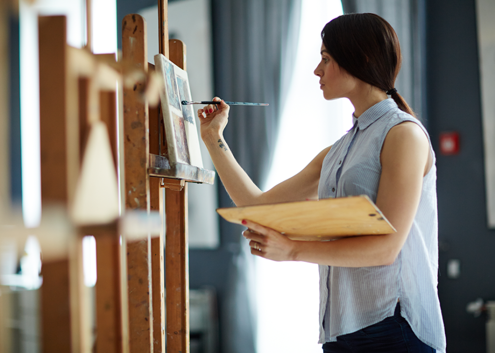 Student painting on canvas in art studio.