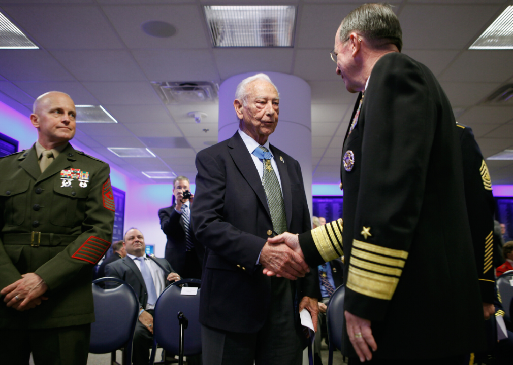 Chairman of the Joint Chiefs of Staff Admiral Mike Mullen (R) greets Medal of Honor recipient U.S. Army Staff Sgt. (retired) Walter Ehlers (C) during a ceremony in Arlington, Virginia, in 2011.