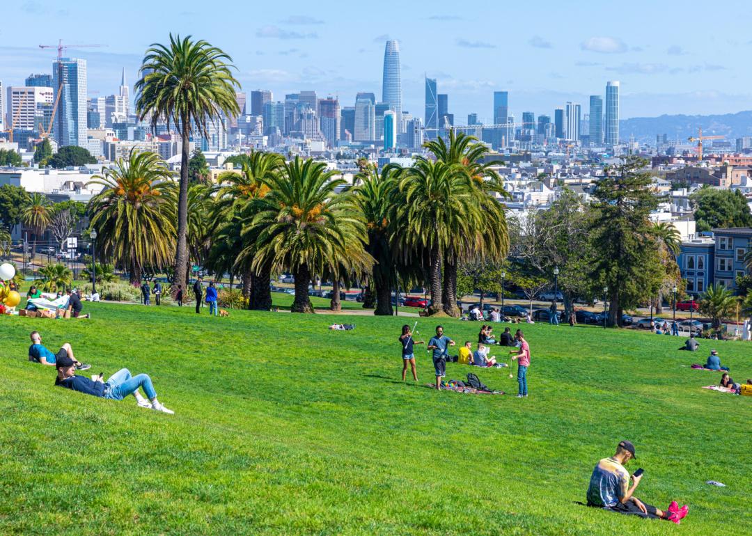 People at Mission Dolores park with San Francisco skyline in the background.