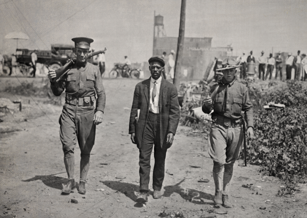 Two National Guardsmen escort a Black man after the East St. Louis massacre.