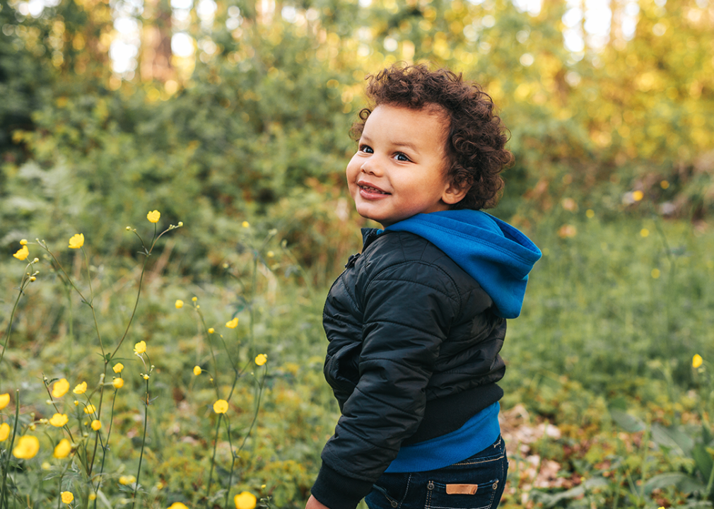 Toddler standing in meadow.