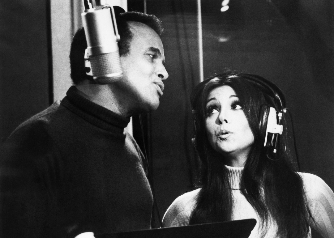 Harry Belafonte and Marlo Thomas sing into microphone.