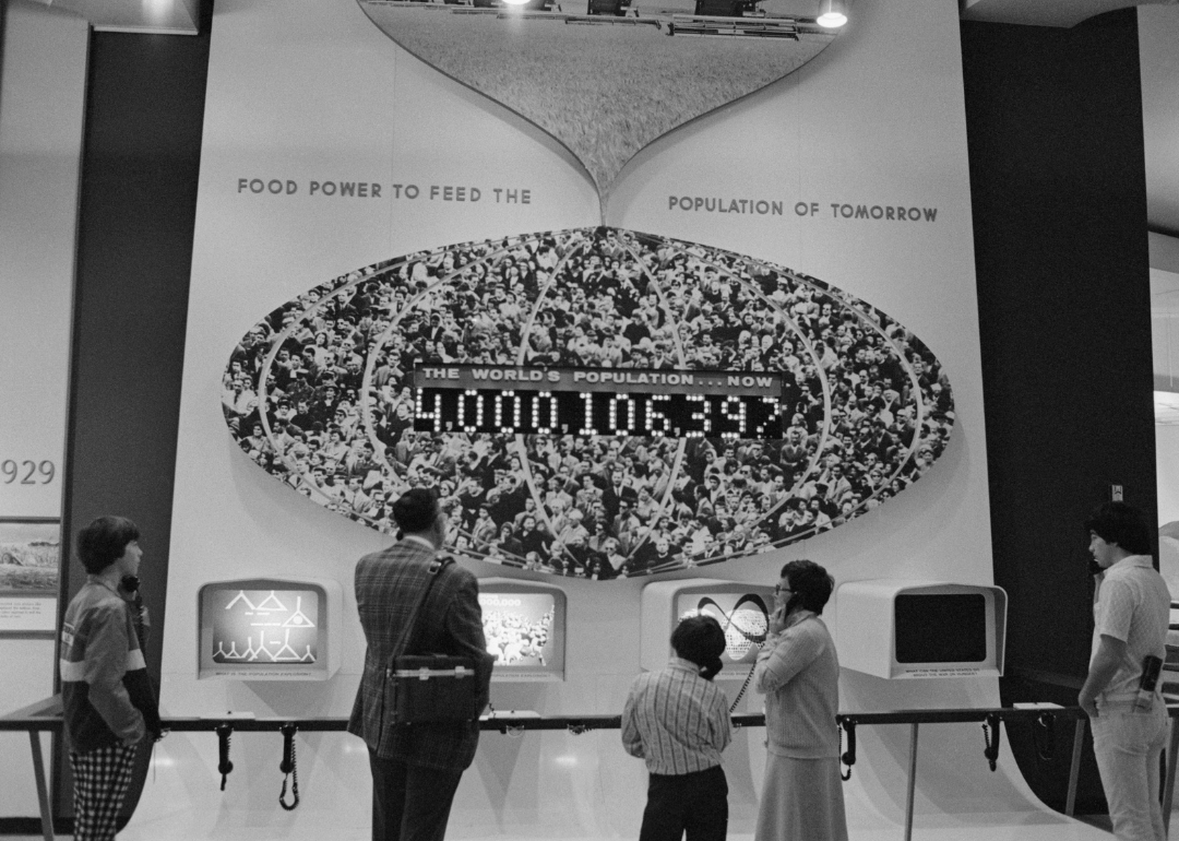 Visitors to Chicago’s Museum of Science and Industry look at world population clock.