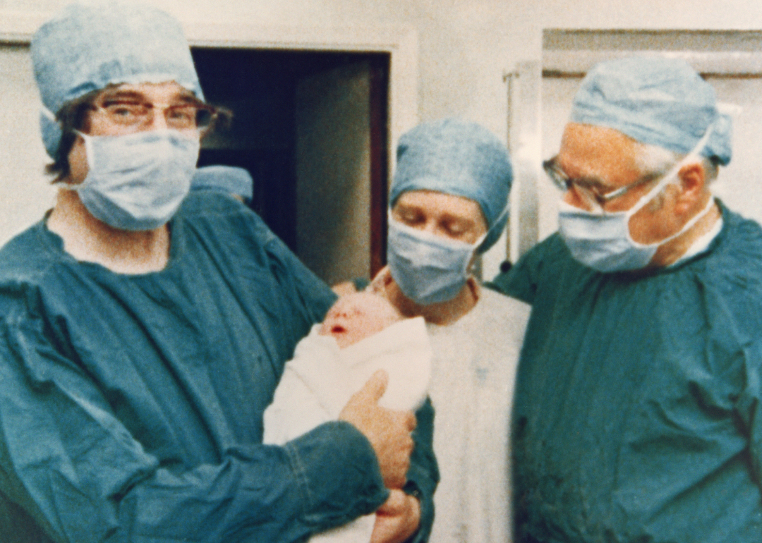 Doctors holding baby Louise Joy Brown.