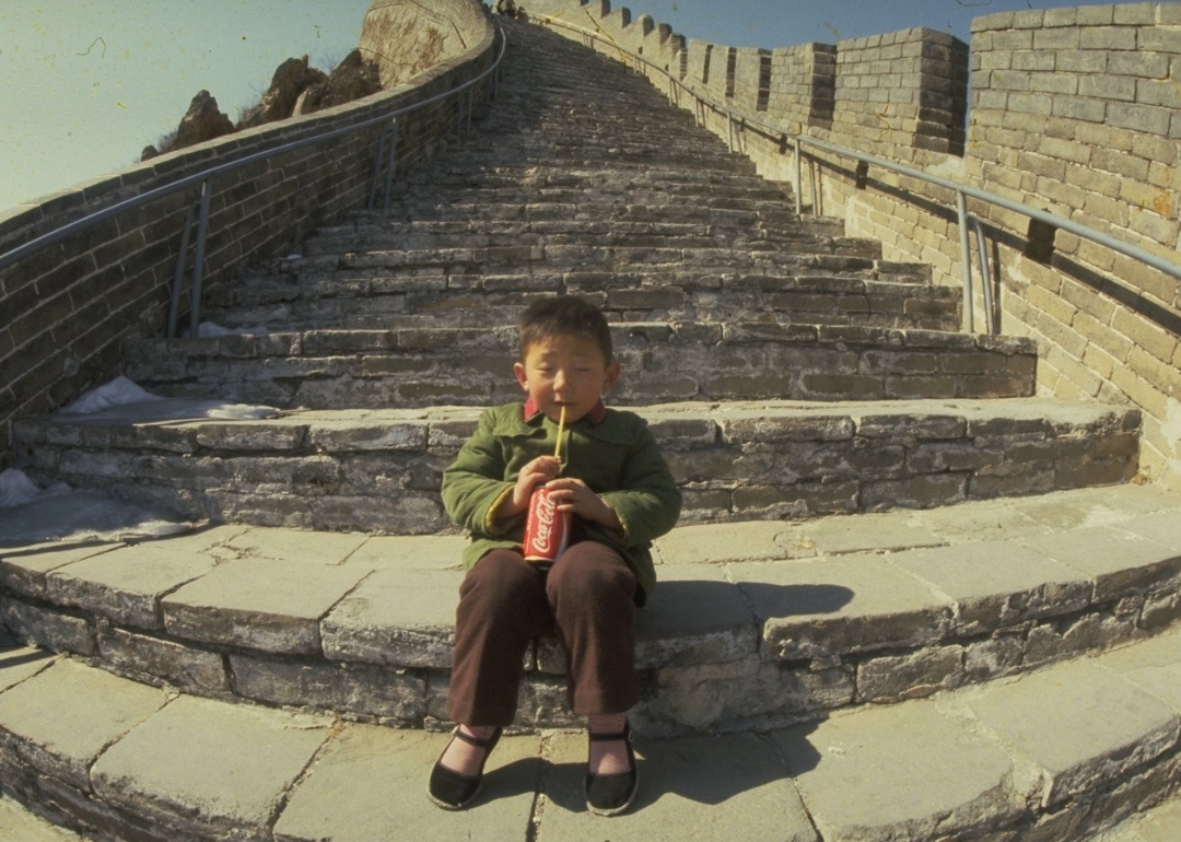 Child drinking Coca-Cola on Great Wall of China.
