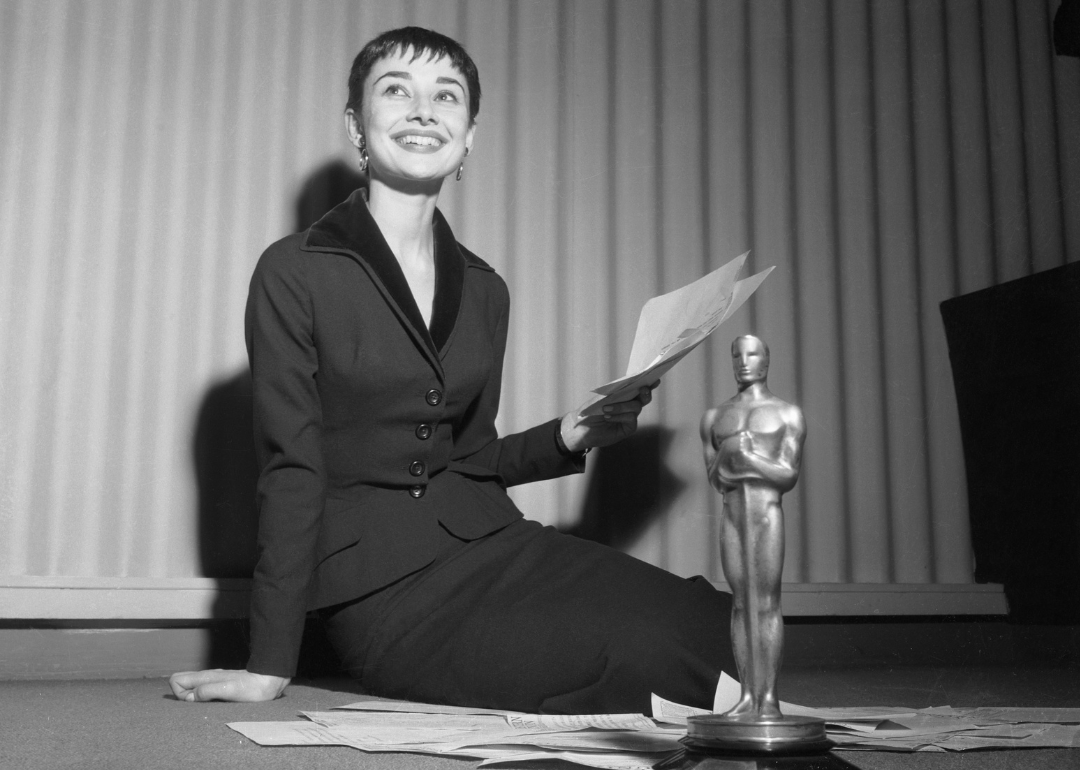 Audrey Hepburn smiles with Oscar holding telegrams.