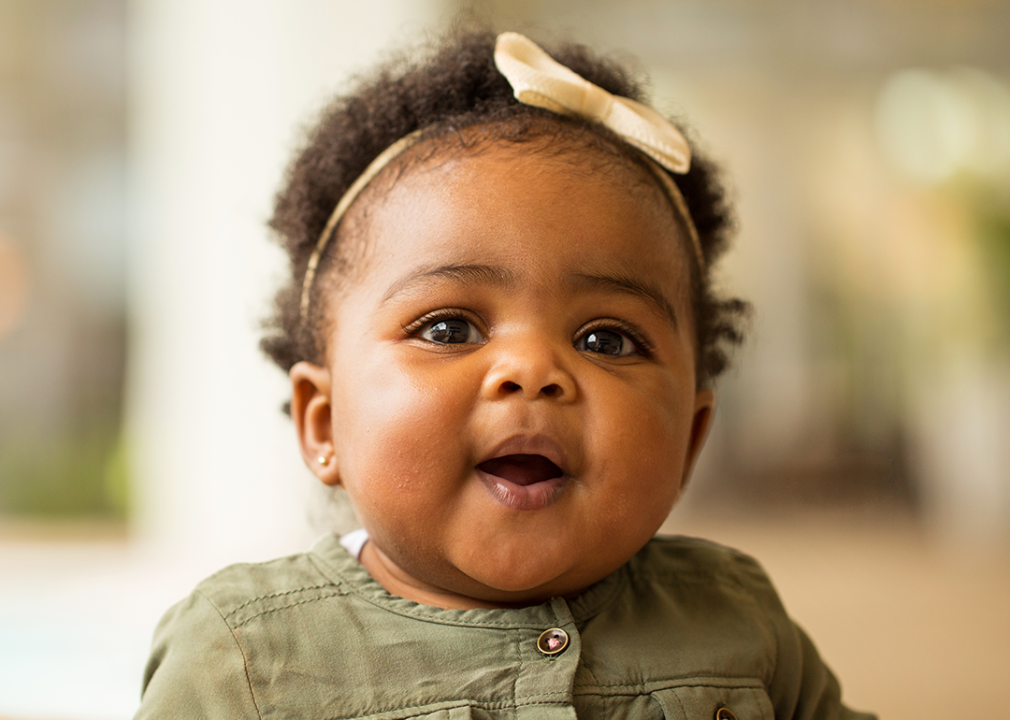 Close up baby with mouth open smiling.