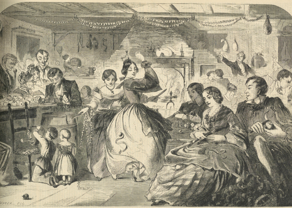 Wood engraving in black ink on paper showing a group of figures paring apples. Woman near fireplace, center, throws an apple peel over her shoulder.