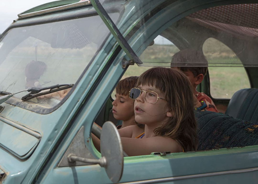 Three children in a car in a scene from Alcarras.