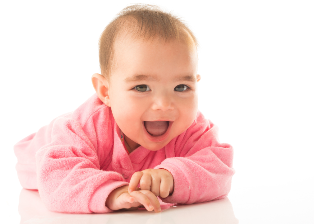 A smiling baby girl wearing a pink top.