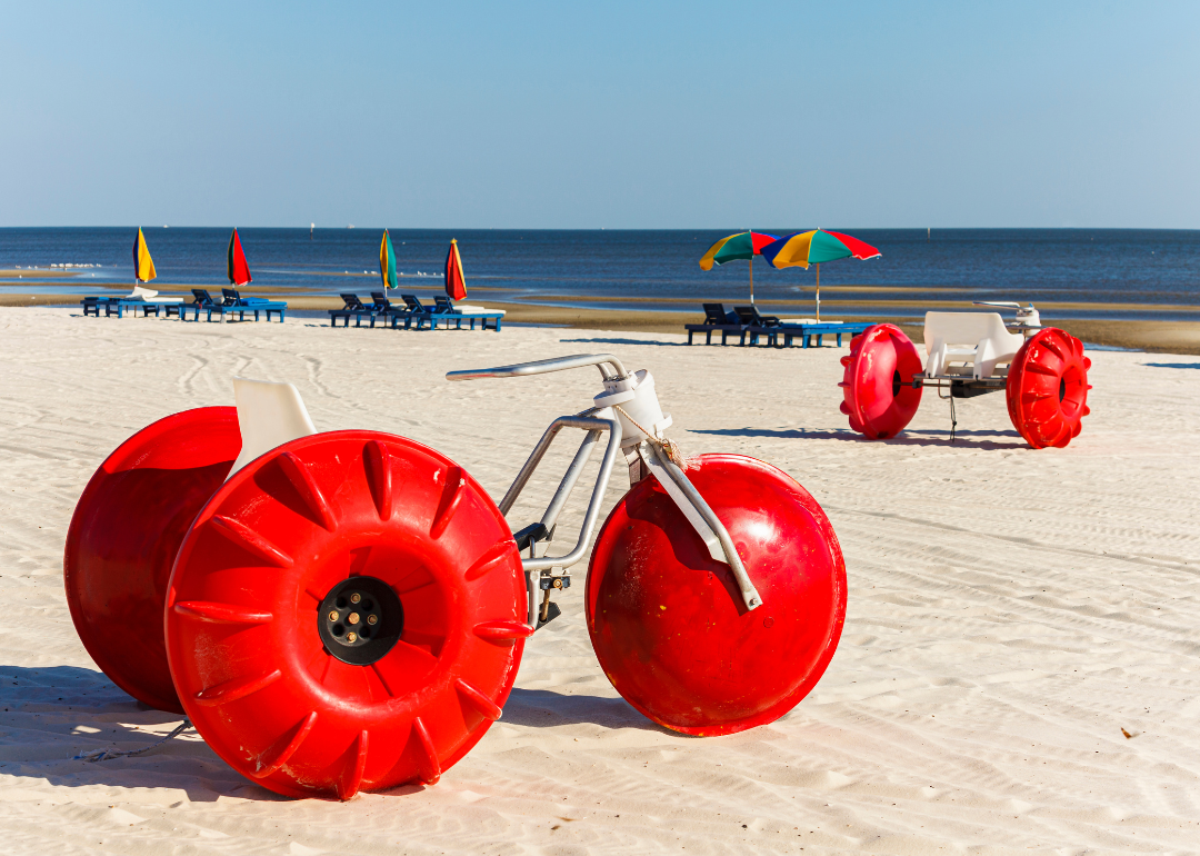 Red tractor bikes and colorful umbrellas on Biloxi Beach.