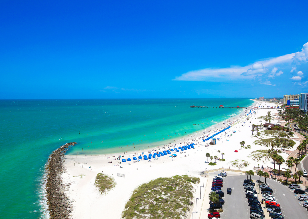 Turquoise water, white sand, and blue umbrellas in Clearwater Beach.