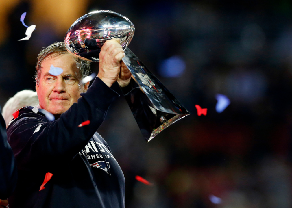 Bill Belichick holding a superbowl trophy.