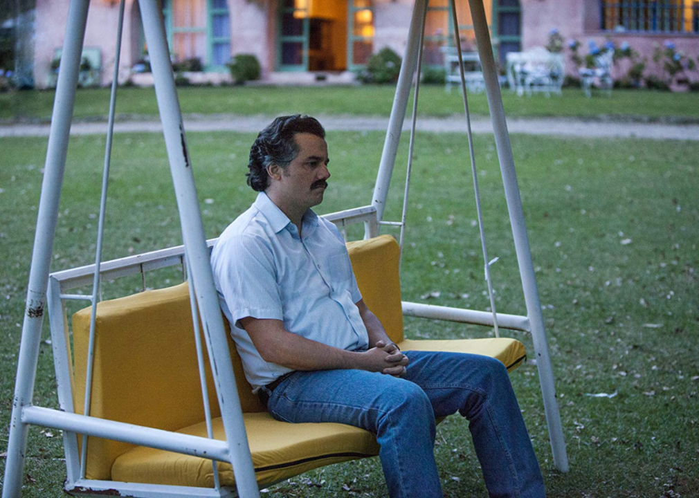 Wagner Moura sits on a swing in a scene from ‘Narcos.’