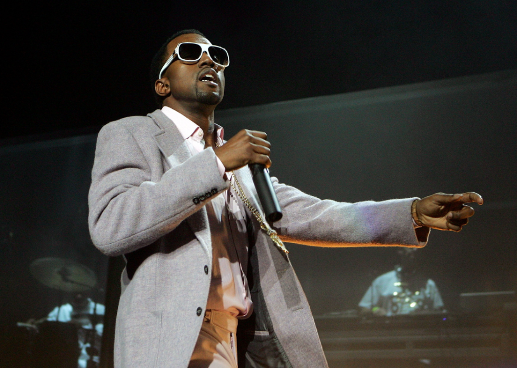 Kanye West wearing sunglasses performs onstage.