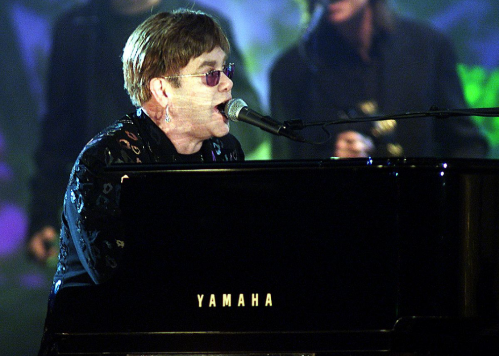 Elton John plays the piano and sings in performance.